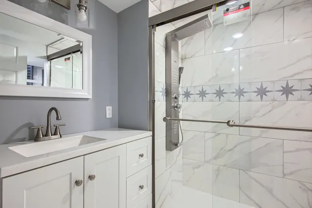 a bathroom with a sink vanity and shower