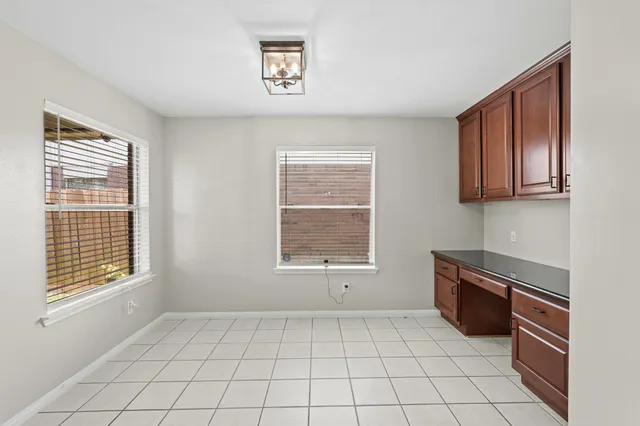 a view of an empty room with a window and cabinet