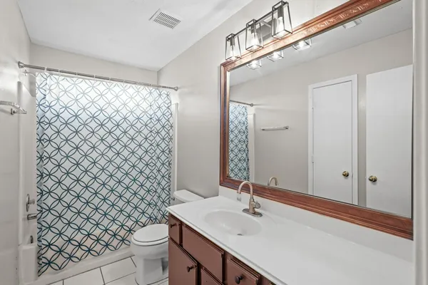 a bathroom with a sink a toilet and shower curtain
