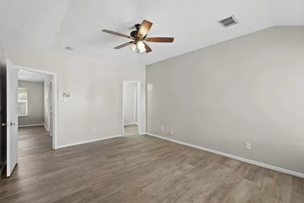 a view of empty room with wooden floor