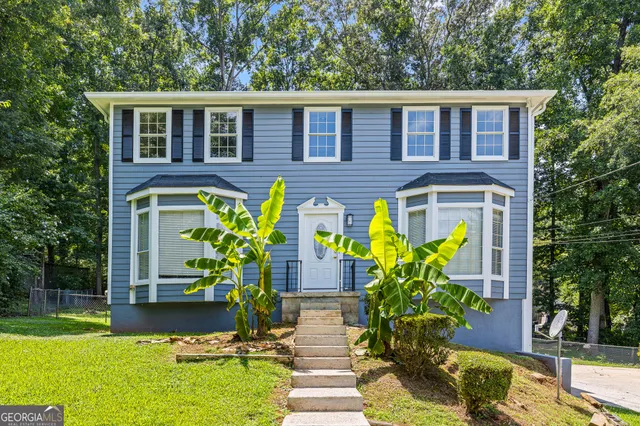 a front view of a house with a garden