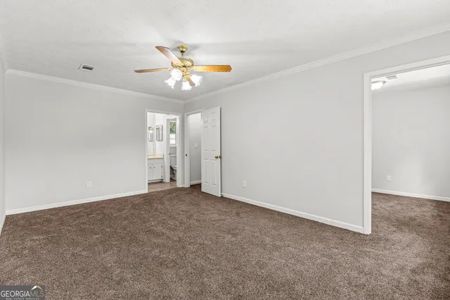 an empty room with windows and fan chandelier fan