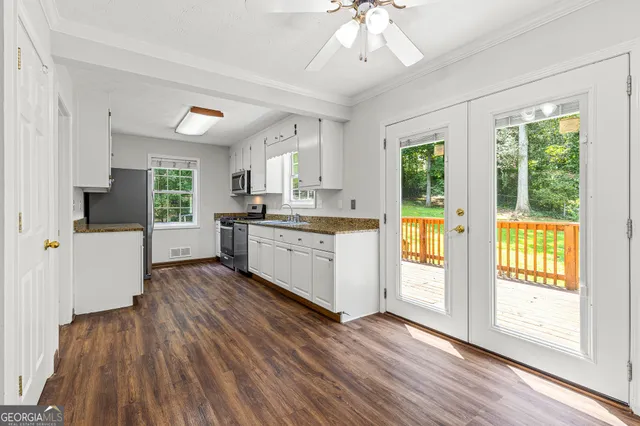 a view of a kitchen with wooden floor and electronic appliances