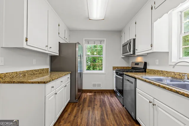 a kitchen with granite countertop wooden floors and white appliances