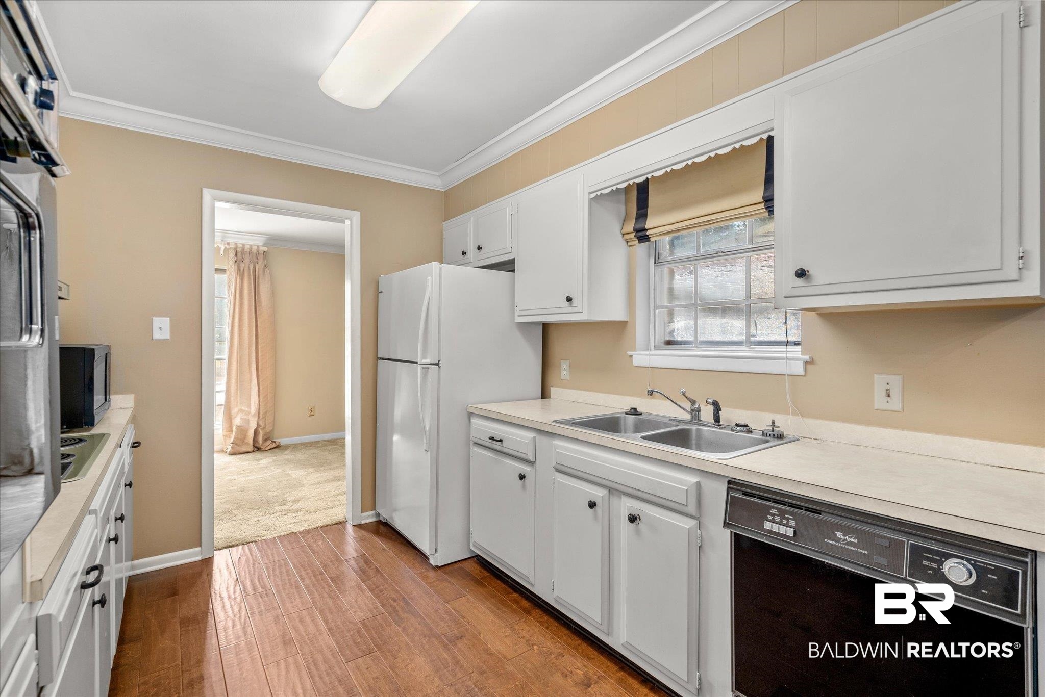 5608 Judson Circle Mobile, AL 36608 - Photo 6 of 20 Kitchen with ornamental molding, white cabinetry, light hardwood / wood-style flooring, black appliances, and sink