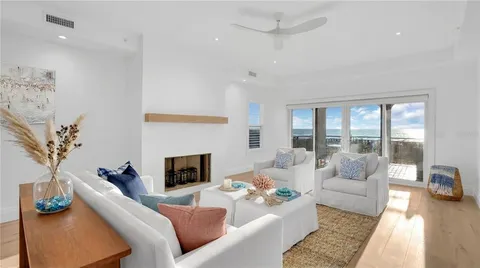 a living room with fireplace furniture and a large window