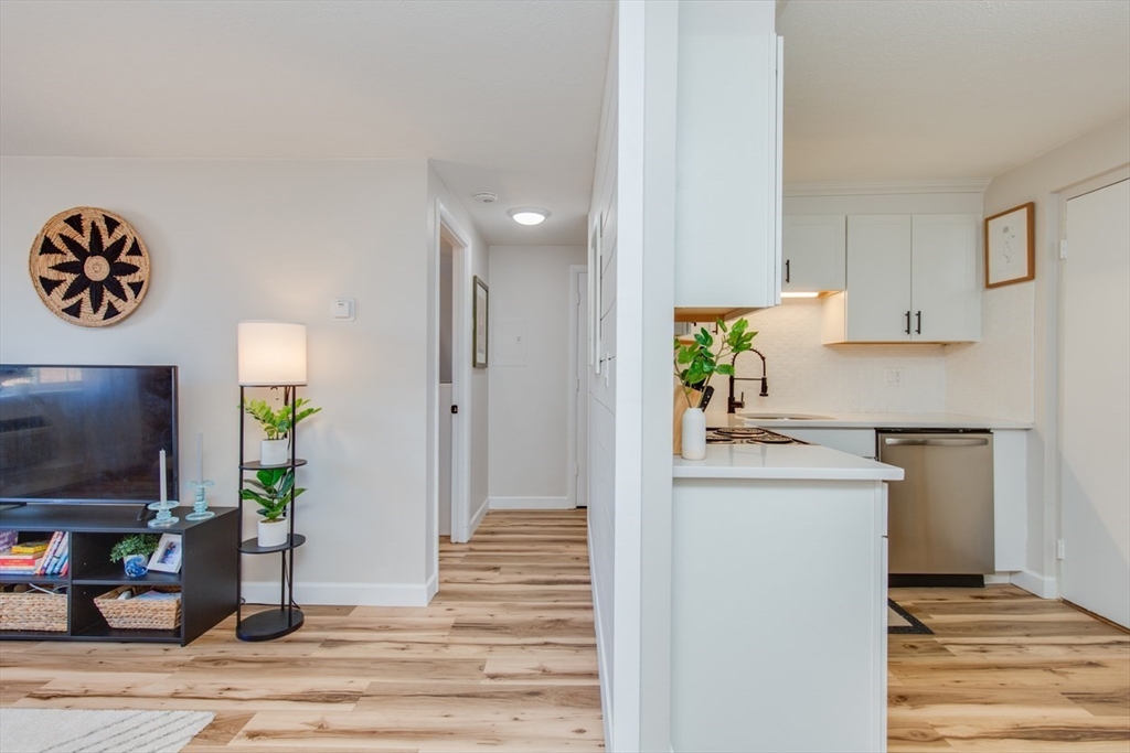 15 Staples Avenue, Unit 46 Everett, MA 02149 - Photo 9 of 35 a kitchen with stainless steel appliances kitchen island granite countertop a refrigerator and a stove top oven
