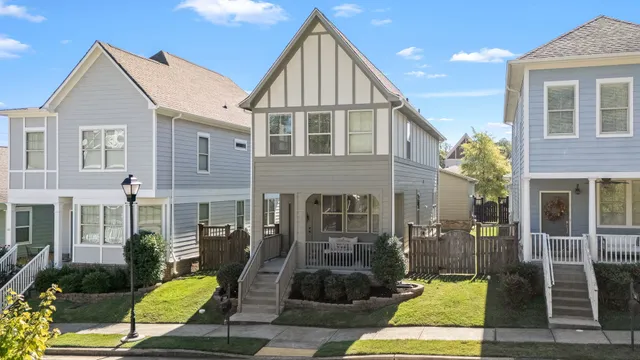 a view of a brick house with large windows and a small yard