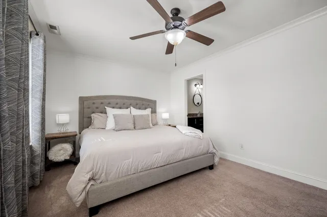 a bedroom with a bed and a ceiling fan