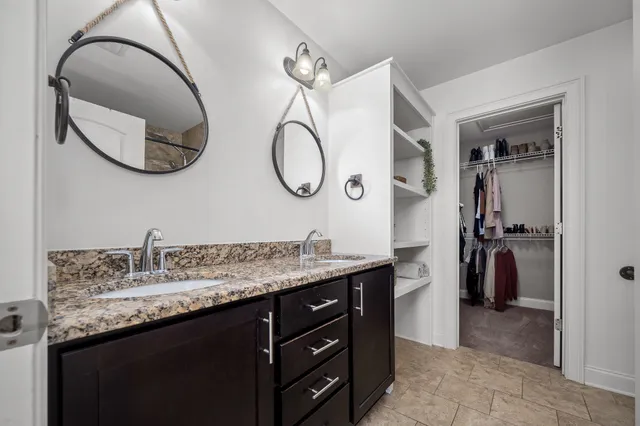 a bathroom with a granite countertop sink and a mirror