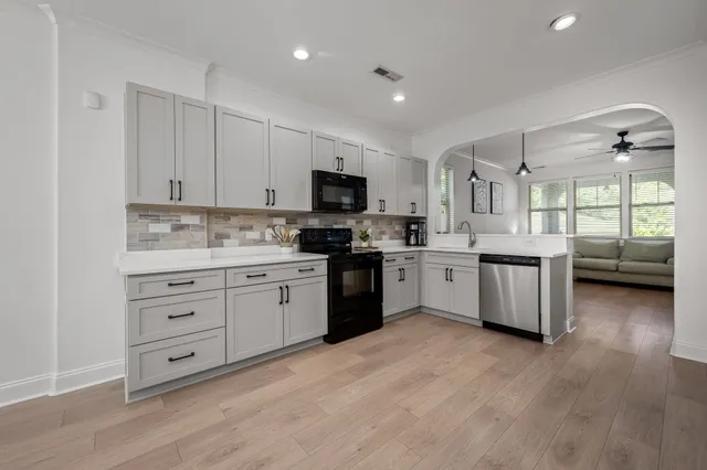 a kitchen with a white cabinets and window