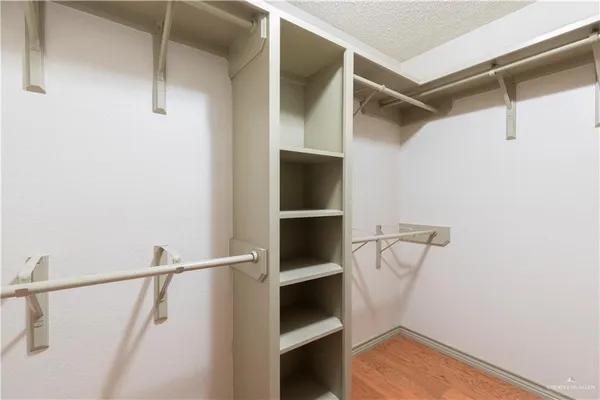 a view of walk in closet with empty racks