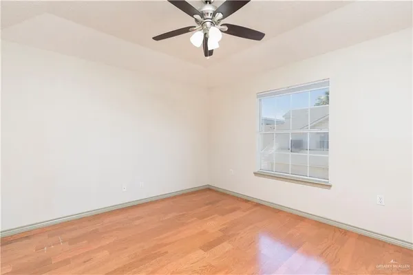 an empty room with a window and a fan