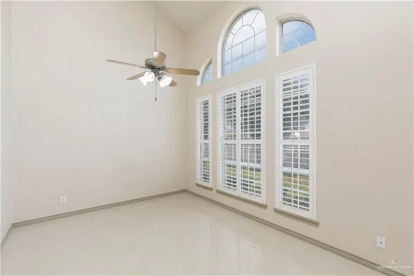 an empty room with windows and fan
