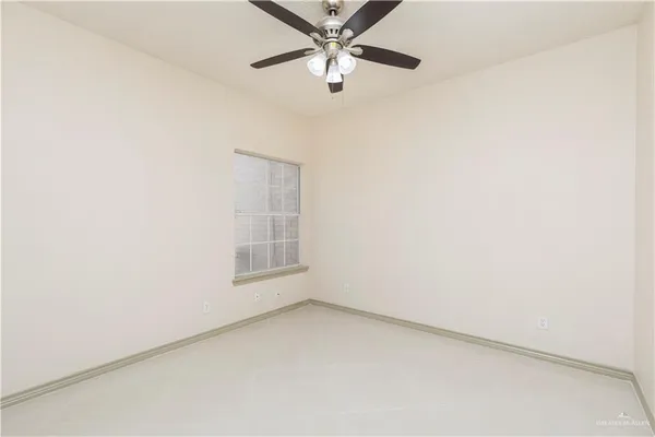 an empty room with a window and a fan