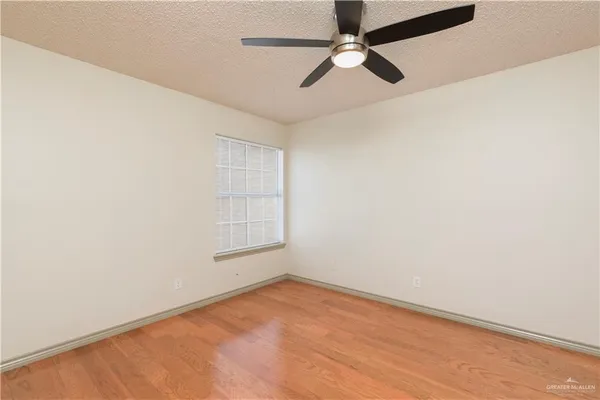 an empty room with a window and a fan