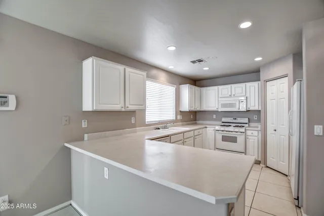 a kitchen with a sink a stove top oven and refrigerator