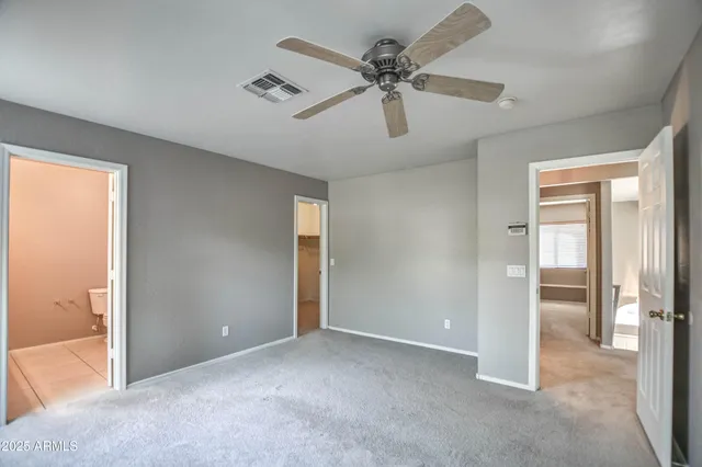a view of a livingroom with a ceiling fan & entryway