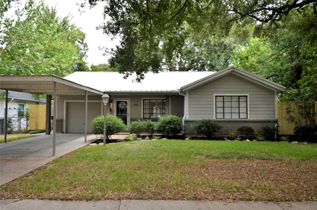 a front view of a house with a yard and trees