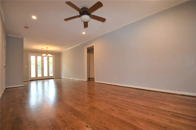 a view of an empty room with window and wooden floor
