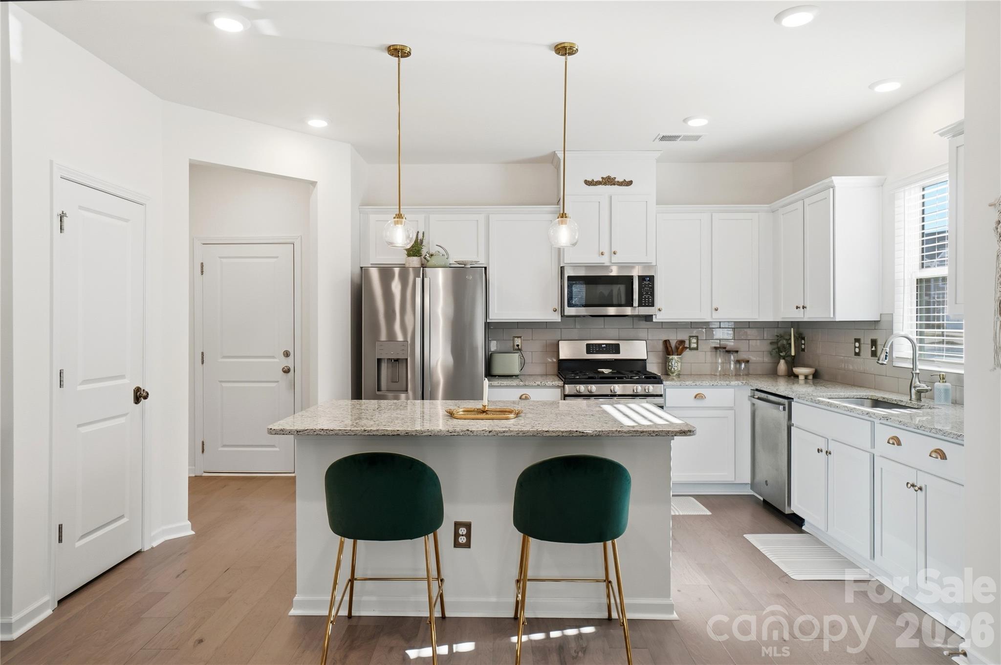 3627 Secrest Landing Monroe, NC 28110 - Photo 10 of 32 a kitchen with stainless steel appliances granite countertop a stove a sink island and a refrigerator