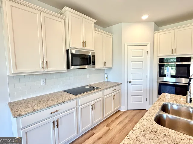 a kitchen with stainless steel appliances granite countertop white cabinets and a granite counter tops
