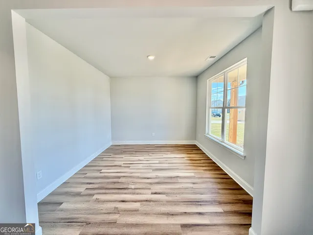 a view of a room with wooden floor and window