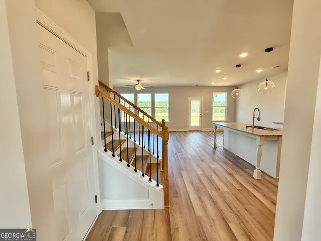a view of a hallway with wooden floor and staircase