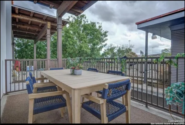 a view of a patio with table and chairs with wooden floor and fence