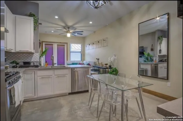 a kitchen with stainless steel appliances a table chairs and a chandelier