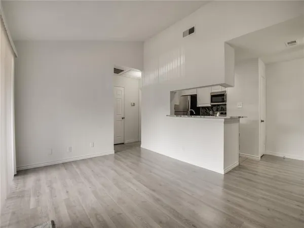 an empty room with wooden floor and fireplace