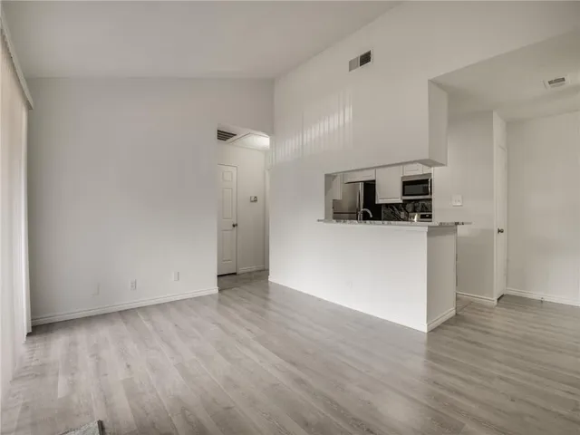 an empty room with wooden floor and fireplace