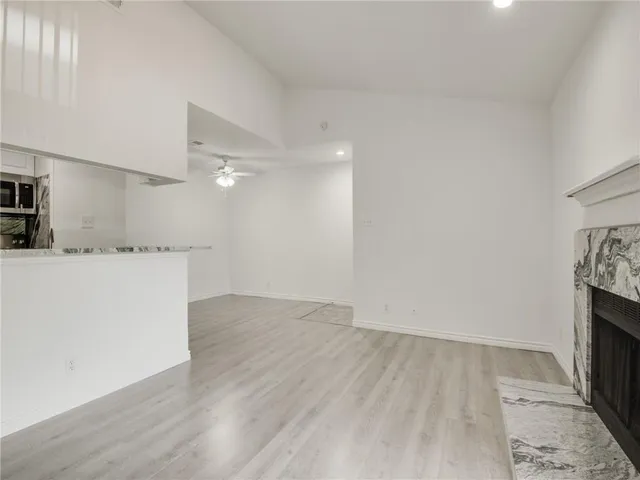 a view of a kitchen with wooden floor and electronic appliances