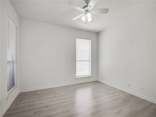 a view of a room with wooden floor and fan