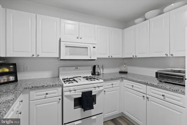 a kitchen with white cabinets and white appliances