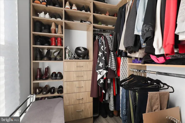 a view of walk in closet with clothes and shoes