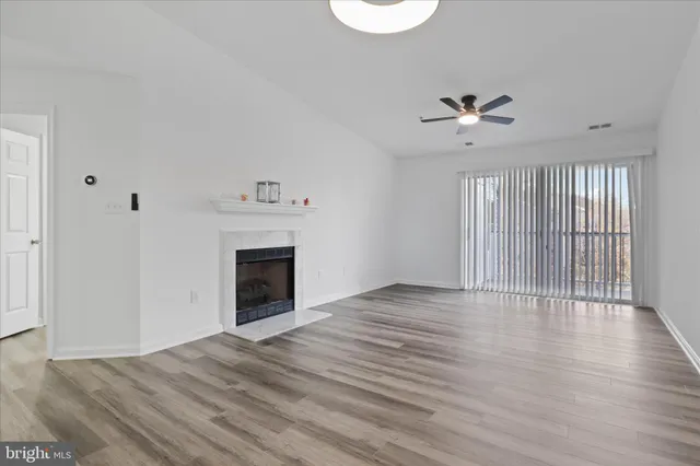 a view of an empty room with a fireplace and a window