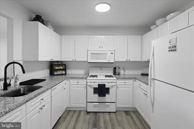 a kitchen with stainless steel appliances granite countertop sink a stove and cabinets