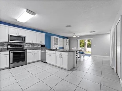 a kitchen with cabinets and chairs
