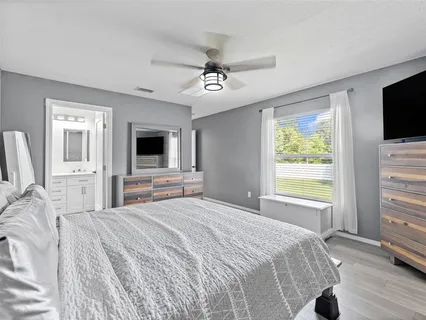 a bedroom with a bed flat screen tv and a window