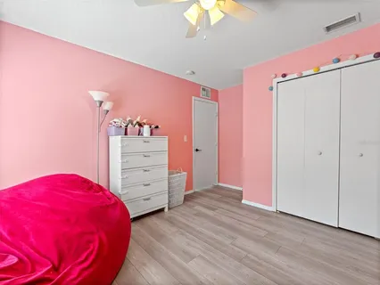 a view of a bedroom with a bed and wooden floor