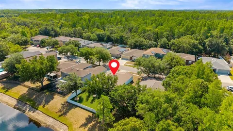 an aerial view of residential houses with outdoor space and trees