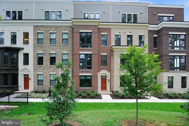 a front view of a residential apartment building with a yard