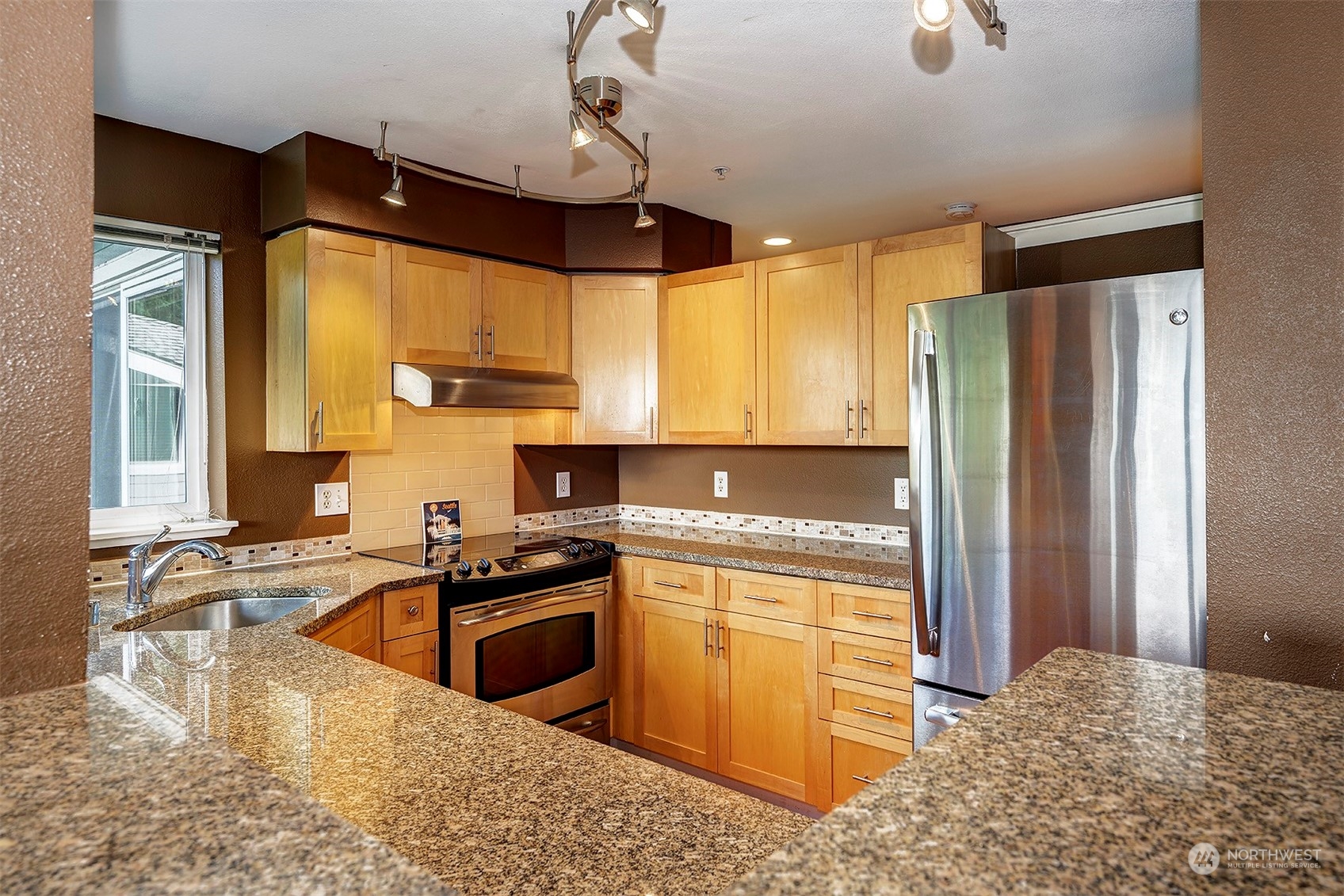 3918 243rd Place Southeast, Unit F303 Bothell, WA 98021 - Photo 9 of 23 a kitchen with stainless steel appliances granite countertop a sink stove and refrigerator