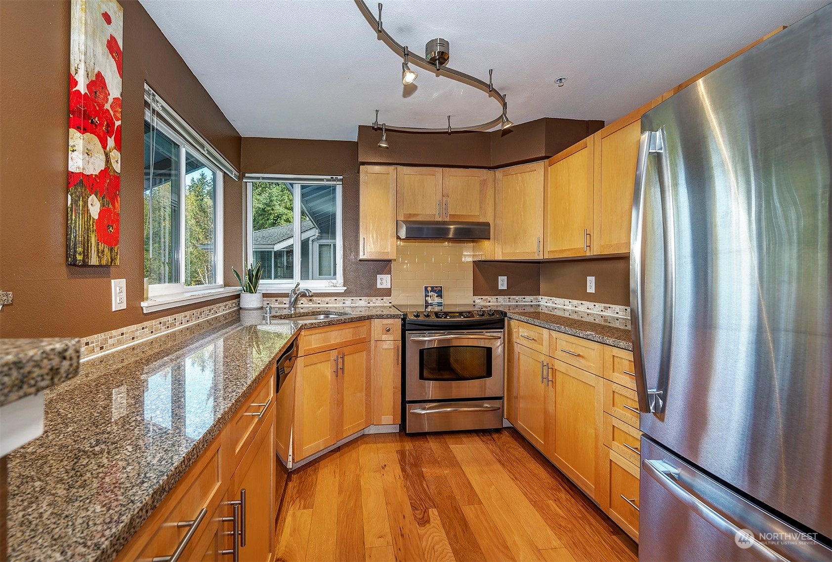 3918 243rd Place Southeast, Unit F303 Bothell, WA 98021 - Photo 10 of 23 a kitchen with stainless steel appliances granite countertop a sink a stove and a refrigerator