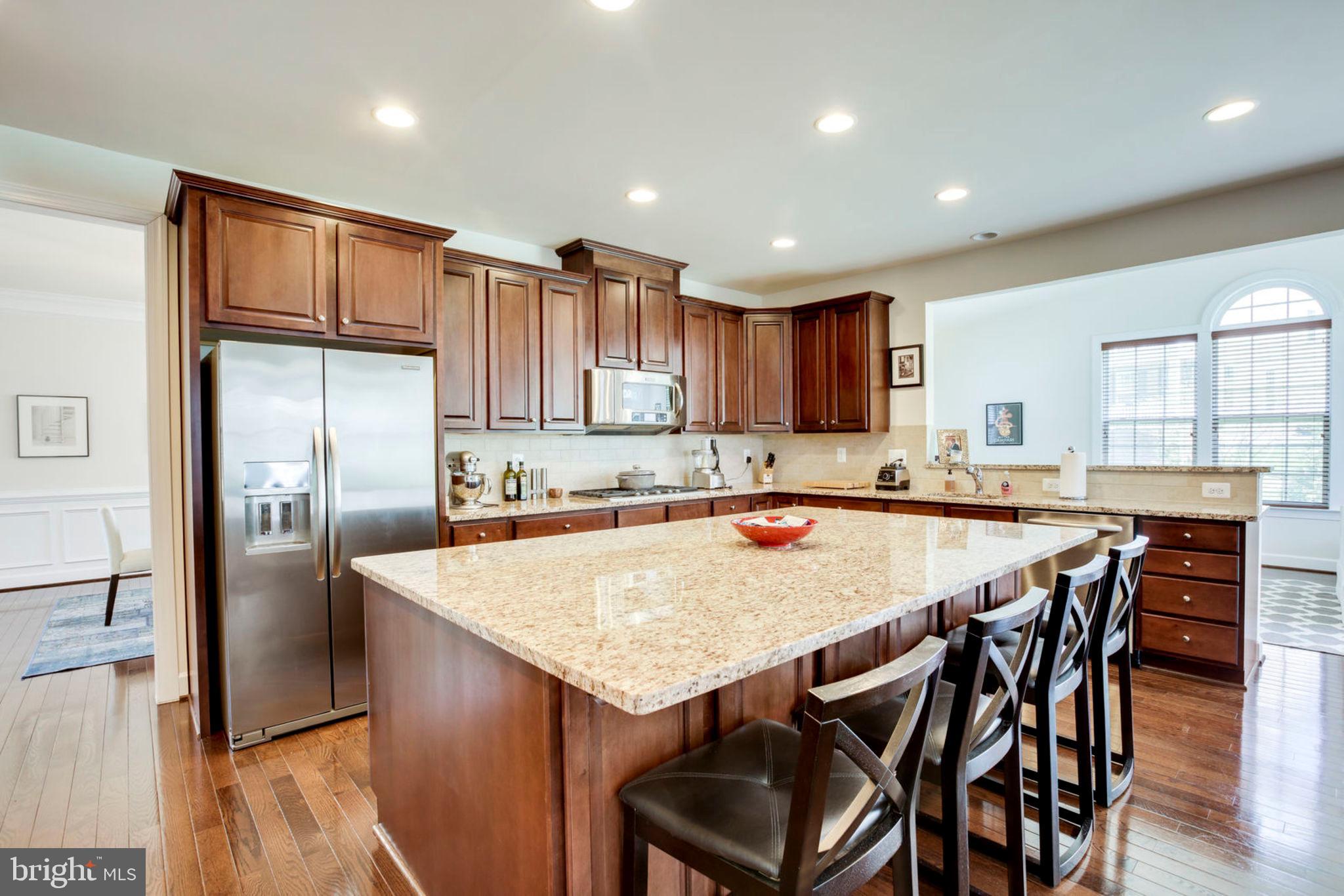1299 Scotts Run Road McLean, VA 22102 - Photo 2 of 22 a kitchen with stainless steel appliances granite countertop a refrigerator a stove a sink a dining table and chairs