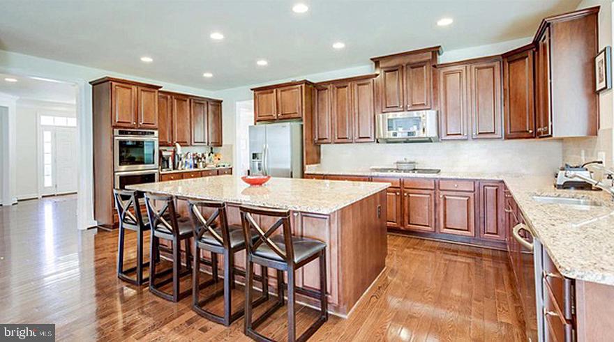 1299 Scotts Run Road McLean, VA 22102 - Photo 11 of 22 a kitchen with stainless steel appliances kitchen island granite countertop a sink and cabinets