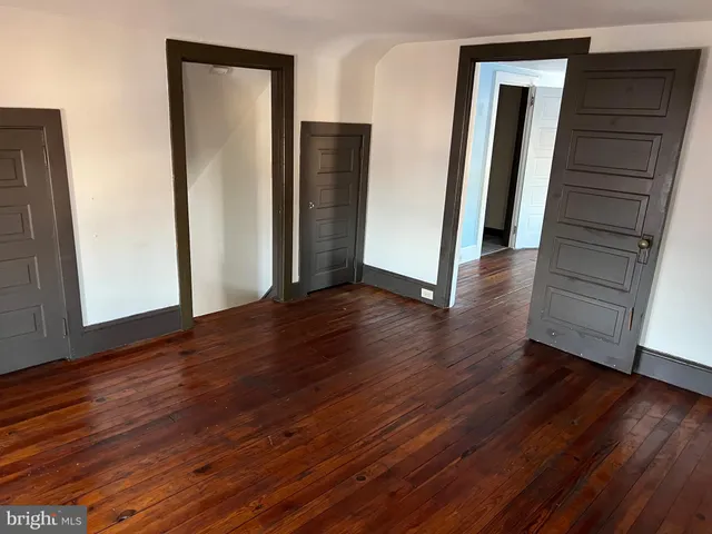 a view of a hallway with wooden floor and closet