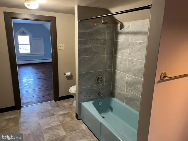 a bathroom with a tub shower vanity and a sink