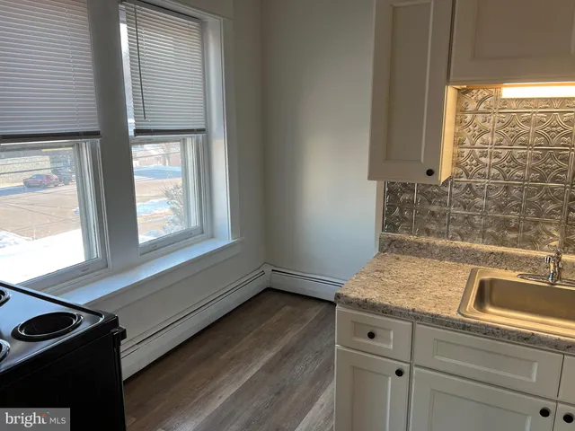 a view of kitchen with a sink a window and cabinets